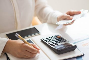 Closeup of person holding bills and calculating them