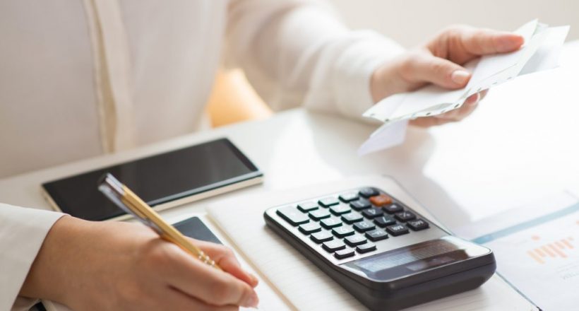 Closeup of person holding bills and calculating them