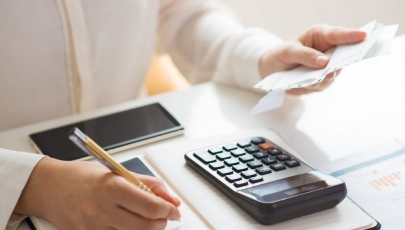 Closeup of person holding bills and calculating them