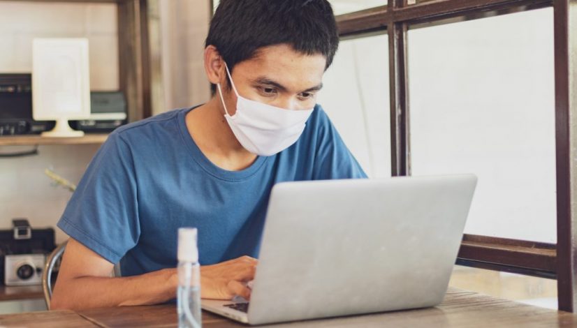 The man wear a mask to protect against the Coronavirus Covid-19, work from home